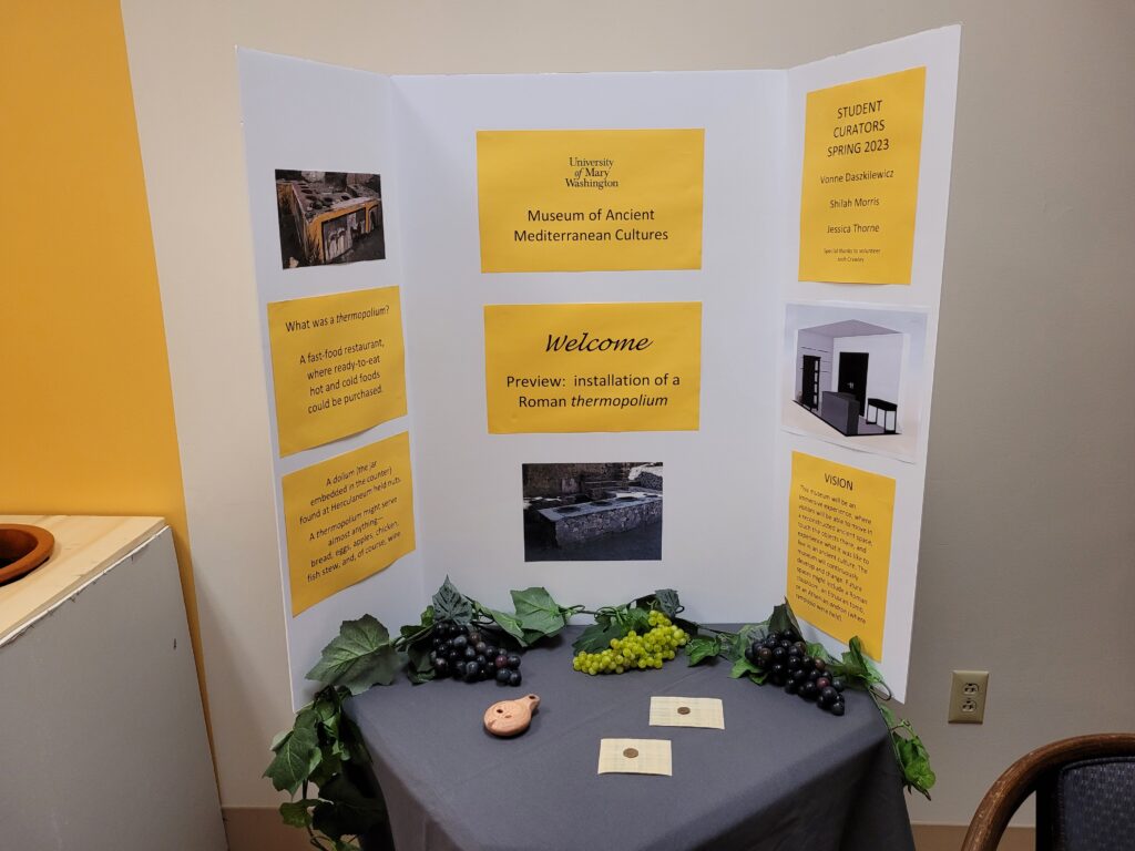 close-up of trifold on small table, on tri fold is information about Roman Thermopolium.